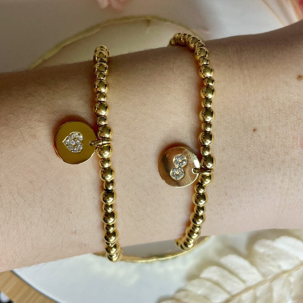 Deux bracelets élastiques en perles d'acier inoxydable doré avec pampilles cœur et infini